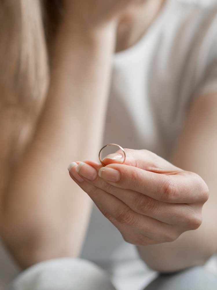 Mujer quitandose anillo de matrimonio